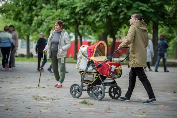 2022年5月23日，俄罗斯塔甘罗格：一名女难民推着婴儿车穿过俄罗斯西南部塔甘罗格附近Krasnydesant村的Kotlostroitel儿童健康中心“Sunny”的一条小路。